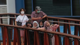 Warga berswafoto di Jembatan Penyeberangan Orang (JPO) Pinisi Karet-Sudirman, Jakarta, Sabtu (7/5/2022). [Suara.com/Angga Budhiyanto]