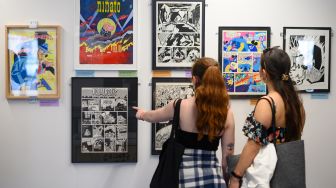 Pengunjung melihat poster saat menghadiri Comic Fair ke-40 di Barcelona, Spanyol, Sabtu (7/5/2022). [Josep LAGO / AFP]
