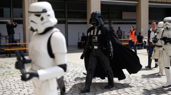 Para cosplayer berdandan seperti karakter Star Wars saat menghadiri Comic Fair ke-40 di Barcelona, Spanyol, Sabtu (7/5/2022). [Josep LAGO / AFP]
