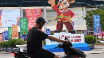 Pengendara sepeda motor melintasi gambar maskot SEA Games 2021 Vietnam, Hanoi Saola, di Kota Bac Ninh, Vietnam, Minggu (8/5/2022). [ANTARA FOTO/Aditya Pradana Putra/YU]