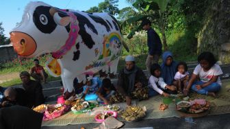 Warga makan bersama pada kendurian Tradisi Lebaran Sapi di lereng Gunung Merapi, Mlambong, Sruni, Musuk, Boyolali, Jawa Tengah, Senin (9/5/2022). [ANTARA FOTO/Aloysius Jarot Nugroho/rwa]