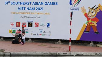 Warga berswa foto dengan latar belakang gambar maskot SEA Games 2021 Vietnam, Hanoi Saola, di Kota Hanoi, Vietnam, Minggu (8/5/2022). [ANTARA FOTO/Aditya Pradana Putra/YU]