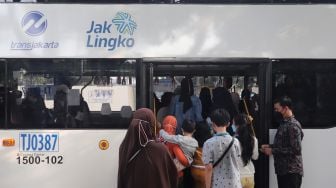 Warga memasuki bus wisata gratis Transjakarta di Jakarta, Selasa (10/5/2022). [Suara.com/Angga Budhiyanto]