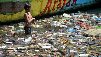 Anak-anak bermain di antara sampah di Sungai Batang Arau, Padang, Sumatera Barat, Rabu (11/5/2022). ANTARA FOTO/Iggoy el Fitra