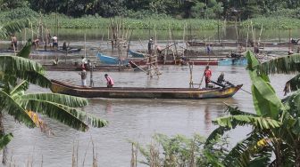 Pekerja menambang pasir menggunakan perahu di tengah aliran sungai Brantas, Kota Kediri, Jawa Timur, Rabu (11/5/2022). ANTARA FOTO/Prasetia Fauzani