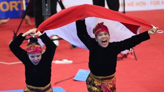 Pesilat Indonesia Riska Hermawan (kiri) dan Ririn Rinasih (kanan) melakukan selebrasi kemenangan usai mengalahkan pesilat Vietnam pada final Seni Ganda Putri Pencak Silat SEA Games 2021 Vietnam di Bac Tu Liem Sport Center, Hanoi, Rabu (11/5/2022). ANTARA FOTO/Zabur Karuru