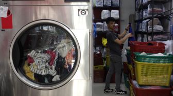 Pekerja memilah pakaian milik pelanggan untuk dikemas di Jourdan Laundry Expert, Ampera Raya, Jakarta, Rabu (11/5/2022). [Suara.com/Angga Budhiyanto]