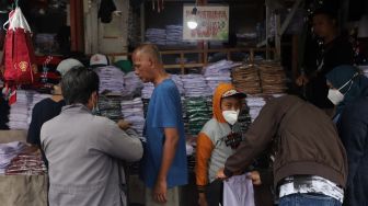 Calon pembeli memilih seragam sekolah di Pasar Jatinegara, Jakarta, Rabu (11/5/2022). [Suara.com/Angga Budhiyanto]