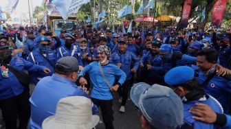 Sejumlah massa buruh berjoget saat melakukan aksi unjuk rasa di kawasan Patung Kuda Arjuna Wiwaha, Jakarta, Kamis (12/5/2022). [Suara.com/Angga Budhiyanto]