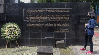 Seorang mahasiswi mengamati Monumen Reformasi 12 Mei 1998 Universitas Trisakti saat peringatan Tragedi Trisakti 12 Mei 1998 di Jakarta, Kamis (12/5/2022). [Suara.com/Angga Budhiyanto]