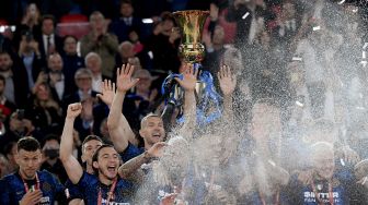 Para pemain Inter merayakan dengan trofi pemenang setelah Inter memenangkan pertandingan sepak bola final Piala Italia (Coppa Italia) antara Juventus melawan Inter di Stadion Olimpico Roma, Kamis (12/5/2022) dini hari WIB.  Filippo MONTEFORTE / AFP