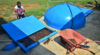 Warga mengecek instalasi tempat pembuatan biogas dari kotoran sapi di Desa Besito, Gebog, Kudus, Jawa Tengah, Kamis (12/5/2022).  ANTARA FOTO/Yusuf Nugroho