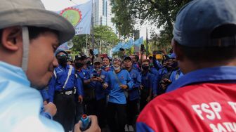 Sejumlah massa buruh berjoget saat melakukan aksi unjuk rasa di kawasan Patung Kuda Arjuna Wiwaha, Jakarta, Kamis (12/5/2022). [Suara.com/Angga Budhiyanto]