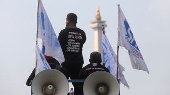 Massa buruh berorasi dari atas mobil komando saat melakukan aksi unjuk rasa di kawasan Patung Kuda Arjuna Wiwaha, Jakarta, Kamis (12/5/2022). [Suara.com/Angga Budhiyanto]
