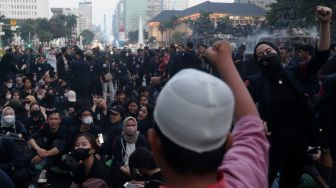 Sejumlah massa mahasiswa Universitas Trisakti menggelar aksi unjuk rasa memperingati Tragedi Trisakti 1998 di kawasan Patung Kuda Arjuna Wiwaha, Jakarta, Kamis (12/5/2022). [Suara.com/Angga Budhiyanto]