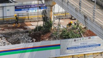 Para pekerja beraktivitas di proyek revitalisasi Halte TransJakarta Sarinah, Jakarta Pusat, Jumat (13/5/2022). [Suara.com/Alfian Winanto]
