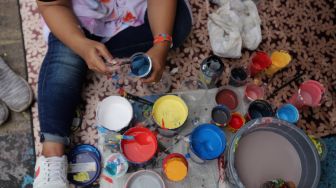 Peserta menyiapkan cat untuk mengikuti lomba melukis dalam acara Gerebek Museum di sekitar Museum Basoeki Abdullah, Jakarta, Sabtu (14/5/2022). [Suara.com/Angga Budhiyanto]