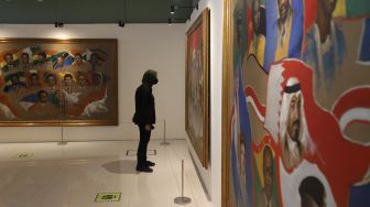 Pengunjung mengamati lukisan yang dipajang di Museum Basoeki Abdullah, Jakarta, Sabtu (14/5/2022). [Suara.com/Angga Budhiyanto]