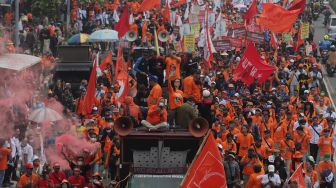 Sejumlah massa buruh melakukan &#039;long march&#039; menuju Stadion Gelora Bung Karno usai berunjuk rasa di depan gedung DPR RI, Jakarta, Sabtu (14/5/2022). [Suara.com/Angga Budhiyanto]