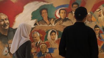 Pengunjung mengamati lukisan yang dipajang di Museum Basoeki Abdullah, Jakarta, Sabtu (14/5/2022). [Suara.com/Angga Budhiyanto]