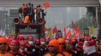 Sejumlah massa buruh melakukan &#039;long march&#039; menuju gedung DPR RI, Jakarta, Sabtu (14/5/2022). [Suara.com/Angga Budhiyanto]