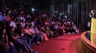 Pengunjung menikmati pertunjukan live di auditorium saat mengunjungi Taman Bollywood di Filmcity Mumbai, India, Jumat (13/5/2022). [SUJIT JAISWAL / AFP]
