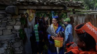 Wanita suku Kalash yang mengenakan pakaian tradisional berjalan menuju rumah kerabat mereka untuk mengumpulkan susu dan menari sebagai bagian dari ritual pada hari pertama festival &#039;Joshi&#039; di desa Bumburet, Pakistan, Sabtu (14/5/2022). [Abdul MAJEED / AFP]
