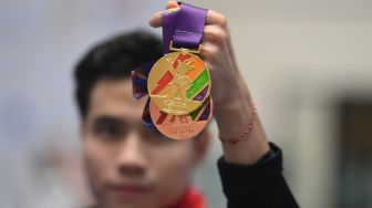 Atlet Wushu Indonesia Seraf Naro Siregar berpose dengan medali yang diraihnya pada Wushu SEA Games 2021 Vietnam di Cau Giay Gymnasium, Hanoi, Vietnam, Minggu (15/5/2021). [ANTARA FOTO/Zabur Karuru/foc]