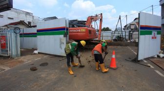 Pekerja beraktivitas di pos pengamanan saat rekayasa lalu lintas di Jalan Otista 3 terkait pekerjaan pembangunan sodetan kali Ciliwung ke Kanal Banjir Timur, Jakarta, Senin (16/5/2022). ANTARA FOTO/Reno Esnir
