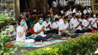Umat Buddha melakukan ibadah Hari Raya Tri Suci Waisak di Vihara Jakarta Dhammacakka Jaya, Jakarta Utara, Senin (16/5/2022). [Suara.com/Alfian Winanto]