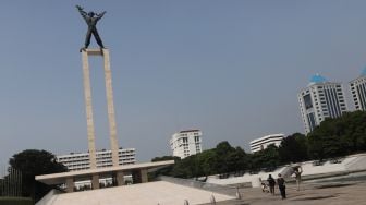 Warga berjalan di Taman Lapangan Banteng, Jakarta, Senin (16/5/2022). [Suara.com/Angga Budhiyanto]