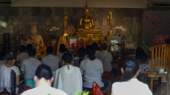 Umat Buddha melakukan ibadah Hari Raya Tri Suci Waisak di Vihara Jakarta Dhammacakka Jaya, Jakarta Utara, Senin (16/5/2022). [Suara.com/Alfian Winanto]