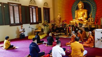 Umat Buddha melakukan ibadah Hari Raya Tri Suci Waisak di Vihara Jakarta Dhammacakka Jaya, Jakarta Utara, Senin (16/5/2022). [Suara.com/Alfian Winanto]