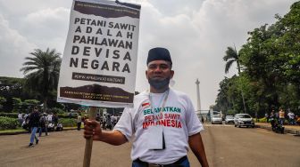 Petani Sawit yang tergabung dalam Asosiasi Petani Kelapa Sawit Indonesia (Apkasindo) menggelar aksi demonstrasi di depan Patung Kuda Arjuna Wijaya, Jakarta Pusat, Selasa (17/5/2022). [Suara.com/Alfian Winanto]