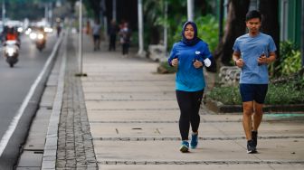 Masyarakat berolahraga di pedestrian kawasan Monas, Jakarta Pusat, Selasa (17/5/2022). [Suara.com/Alfian Winanto]