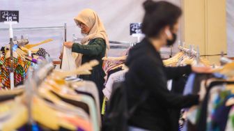 Warga memilih pakaian bekas layak pakai (thrifting) yang dijual di Mal Blok M, Jakarta Selatan, Selasa (17/5/2022). [Suara.com/Alfian Winanto]
