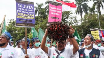 Petani Sawit yang tergabung dalam Asosiasi Petani Kelapa Sawit Indonesia (Apkasindo) menggelar aksi demonstrasi di depan Patung Kuda Arjuna Wijaya, Jakarta Pusat, Selasa (17/5/2022). [Suara.com/Alfian Winanto]