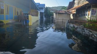 Warga melewati banjir rob yang menggenangi kawasan perkampungan nelayan di Purus Atas, Kota Padang, Sumatera Barat, Rabu (18/5/2022).  ANTARA FOTO/Iggoy el Fitra
