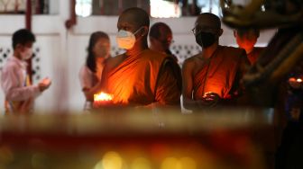 Pemuka agama Buddha berrsama warga membawa lilin pada rangkaian perayaan Tri Suci Waisak 2566 BE/2022 di Vihara Dharma Bhakti, Banda Aceh, Aceh, Kamis (19/5/2022). [ANTARA FOTO / Irwansyah Putra/tom]
