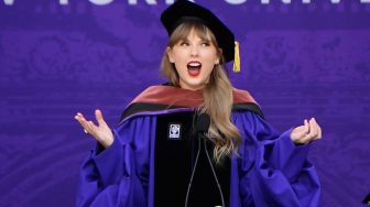 Penyanyi Taylor Swift menyampaikan pidato saat upacara kelulusan New York University angkatan 2022 di Stadion Yankee, New York, Amerika Serikat, Rabu (18/5/2022). [Angela Weiss / AFP]
