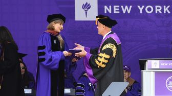 Penyanyi Taylor Swift menerima gelar doktor kehormatan seni rupa saat upacara kelulusan New York University angkatan 2022 di Stadion Yankee, New York, Amerika Serikat, Rabu (18/5/2022). [Angela Weiss / AFP]
