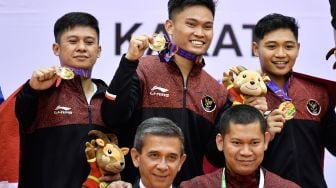 Karateka Indonesia Andy Tomy (kiir), Andi Dasril (tengah atas), Albiadi (kanan atas), Wakil Presiden Federasi Karate Asia Tenggara Darly SIregar (kiri bawah) serta Sekjen PB FORKI Raja Sapta Ervian (kanan bawah) berpose dengan medali emas yang diraihnya pada final Kata Beregu Putra SEA Games 2021 Vietnam di di Sports Competition Center, Ninh Binh, Vietnam, Jumat (20/5/2022). [ANTARA FOTO/Zabur Karuru/foc]