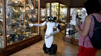 Robot humanoid R1 saat memandu pengunjung di ruang keramik museum Palazzo Madama, Turin, Italia, Kamis (12/5/2022). [MARCO BERTORELLO / AFP]