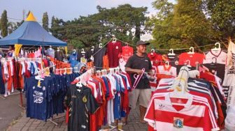 Senyum Bahagia Pedagang Merchandise Bola pada Laga Uji Coba Arema FC Versus PSIS di Stadion Kanjuruhan Malang