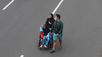 Warga berolahraga di area &#039;car free day&#039; (CFD) di Jalan Jenderal Sudirman, Jakarta, Minggu (22/5/2022). [Suara.com/Angga Budhiyanto]