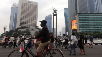Warga berolahraga di area &#039;car free day&#039; (CFD) di kawasan Bundaran Hotel Indonesia, Jakarta, Minggu (22/5/2022). [Suara.com/Angga Budhiyanto]