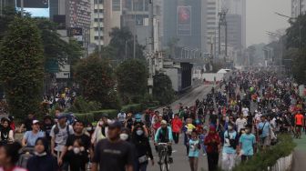 Warga berolahraga di area 'car free day' (CFD) di Jalan Jenderal Sudirman, Jakarta, Minggu (22/5/2022). [Suara.com/Angga Budhiyanto]