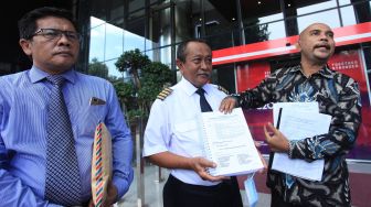 Mantan pilot maskapai Merpati Nusantara Airlines Muhamad Trisiswa (tengah) didampingi kuasa hukum Tim Advokasi Paguyuban Pilot Eks Merpati Nusantara Airlines David Sitorus (kanan) dan Lamsihar Rumahorbo (kiri) menunjukkan berkas laporan usai melapor ke KPK di Jakarta, Senin (23/5/2022). ANTARA FOTO/Reno Esnir