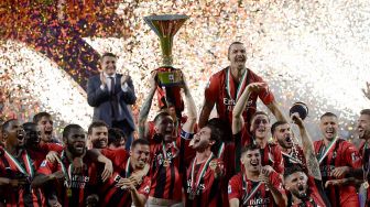 Para pemain AC Milan mengangkat trofi juara Liga Italia setelah AC Milan memenangkan pertandingan sepak bola Serie A Italia antara Sassuolo melawan AC Milan Minggu (22/5/2022) malam waktu setempat atau Senin (23/5/2022) dini hari .  [AFP Photo]