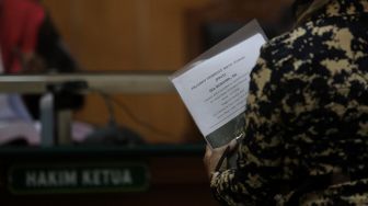 Saksi yang dihadirkan membawa  berkas untuk diperiksa oleh hakim ketua saat sidang lanjutan kasus mafia tanah yang melibatkan artis Nirina Zubir di Pengadilan Negeri (PN) Jakarta Barat, Selasa (24/5/2022). [Suara.com/Angga Budhiyanto]